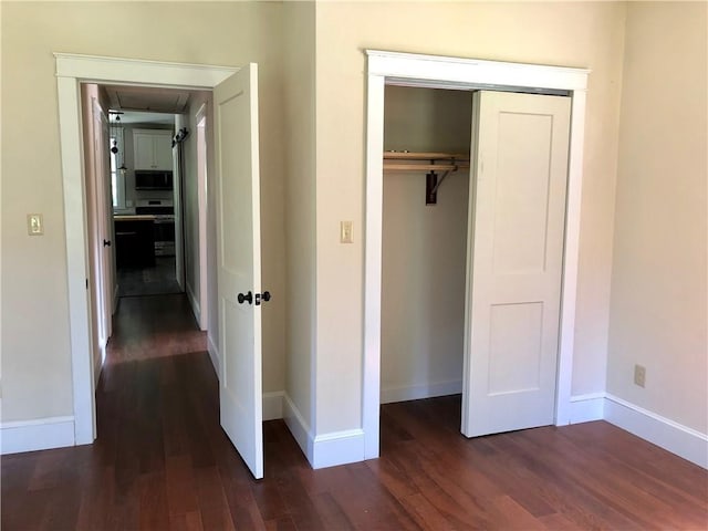 65 Boris Rd, Bloomingburg, NY 12721 - unfurnished bedroom with dark wood finished floors, baseboards, and a closet