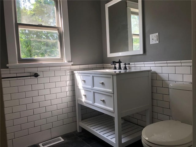 65 Boris Rd, Bloomingburg, NY 12721 - bathroom with a wainscoted wall, plenty of natural light, toilet, and tile walls