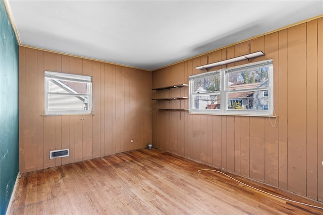 spare room with hardwood / wood-style floors and visible vents