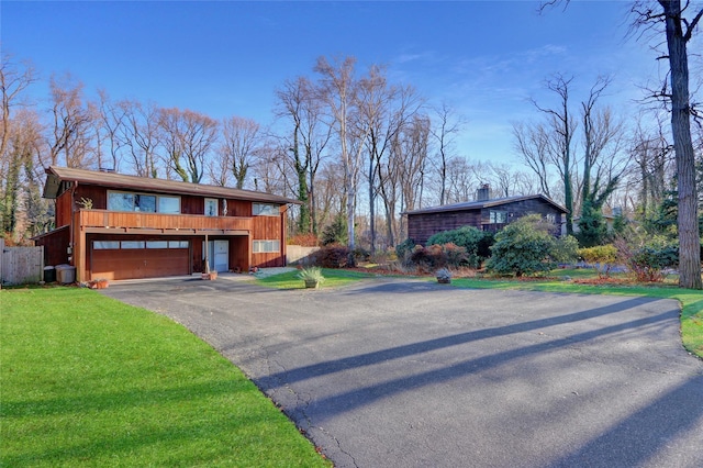 view of front of home featuring a front yard, a garage, driveway, and a chimney