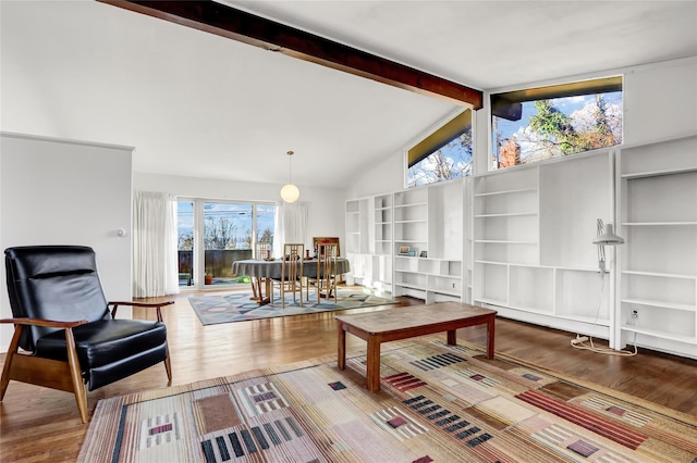 living room featuring beam ceiling, wood finished floors, and a wealth of natural light