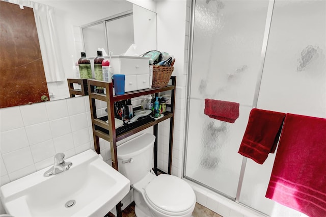 full bathroom with a sink, decorative backsplash, a shower stall, tile walls, and toilet