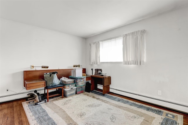 office area featuring a baseboard heating unit and wood finished floors