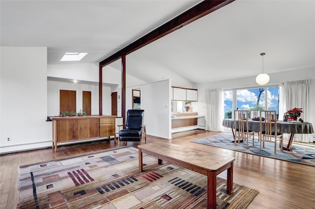 living area featuring hardwood / wood-style flooring, vaulted ceiling with skylight, and baseboard heating