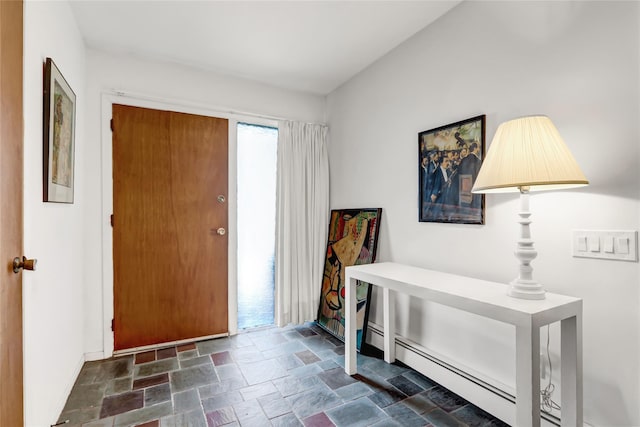 foyer entrance with stone finish floor, baseboards, and baseboard heating