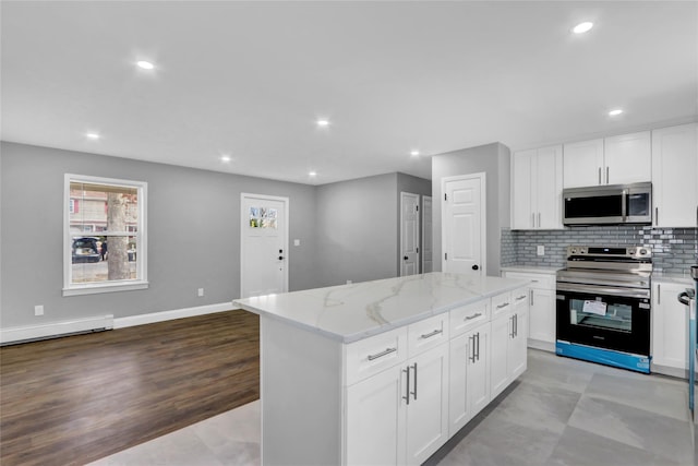 kitchen with light stone counters, a baseboard heating unit, tasteful backsplash, a kitchen island, and stainless steel appliances