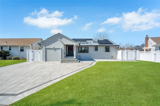 view of front of home featuring solar panels, a front yard, decorative driveway, a garage, and a gate