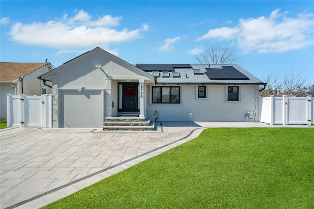 view of front of home featuring a front yard, a gate, an attached garage, and stucco siding