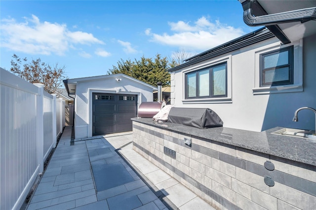 view of patio featuring area for grilling, a grill, an outdoor structure, and fence