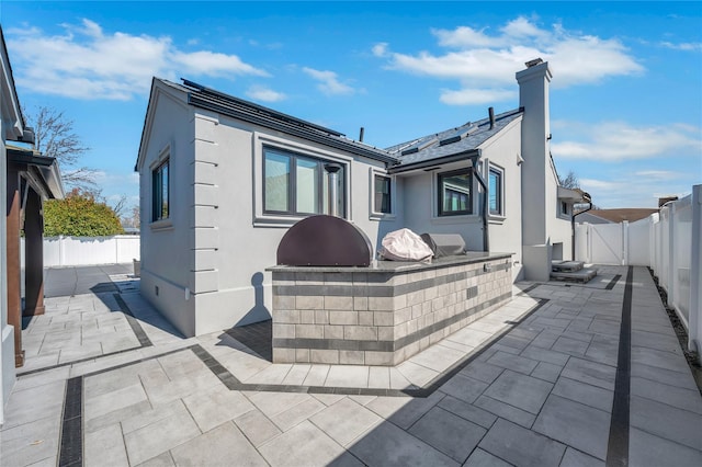 back of property with a patio area, a fenced backyard, and stucco siding