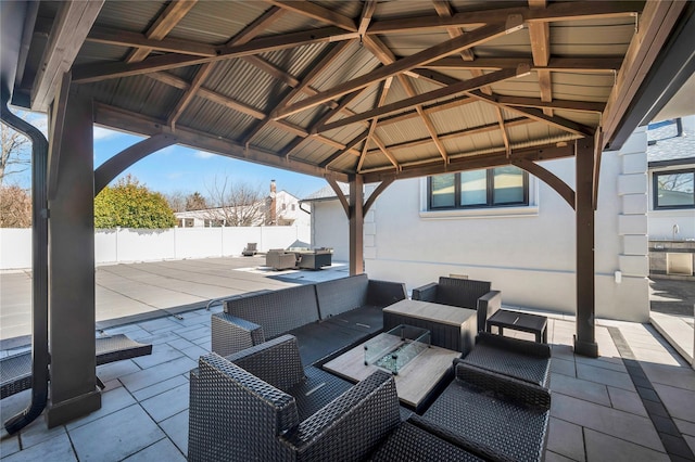 view of patio / terrace featuring an outdoor living space with a fire pit, a gazebo, and fence