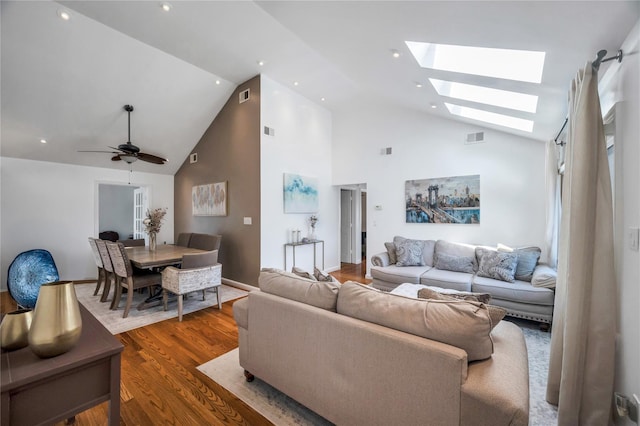 living area featuring visible vents, a skylight, and wood finished floors