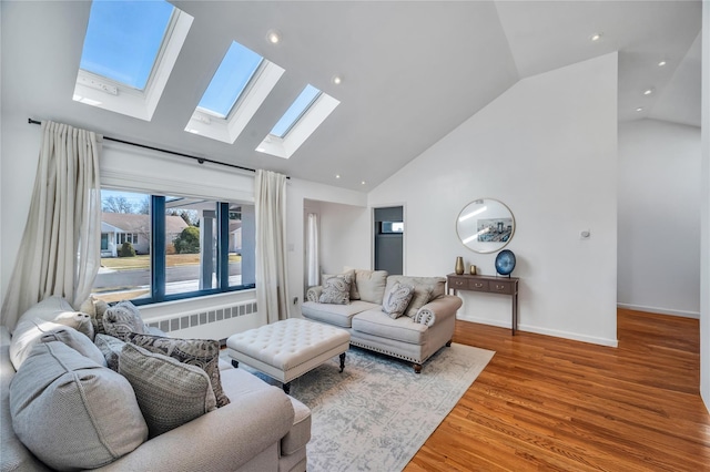 living room featuring wood finished floors, baseboards, high vaulted ceiling, radiator heating unit, and recessed lighting