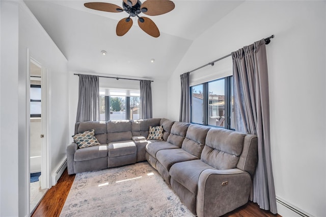 living area featuring wood finished floors, lofted ceiling, and a baseboard radiator