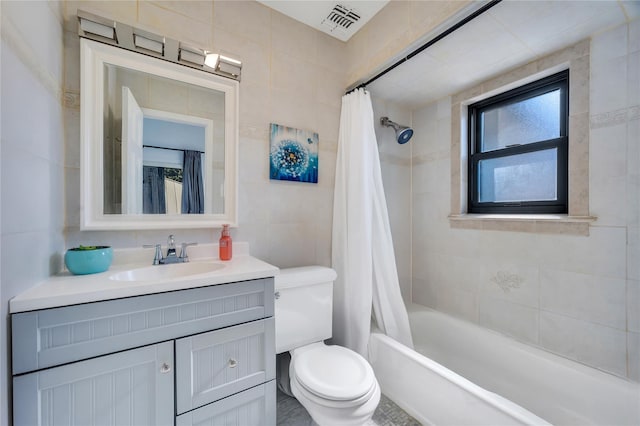 full bathroom with visible vents, shower / tub combo with curtain, toilet, tile walls, and vanity