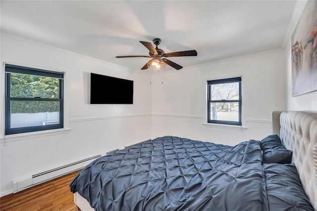 bedroom with ceiling fan, baseboard heating, wood finished floors, and ornamental molding