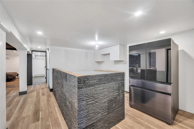 kitchen featuring light wood finished floors, recessed lighting, and white cabinetry