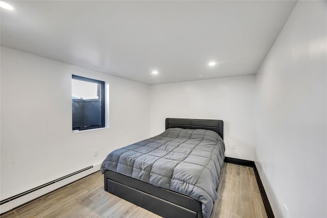 bedroom featuring recessed lighting, a baseboard radiator, baseboards, and wood finished floors