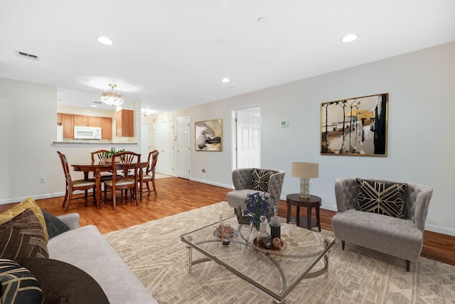 living room with recessed lighting, baseboards, and light wood-style flooring