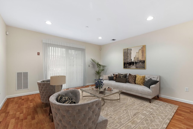 living room with visible vents, baseboards, and wood finished floors