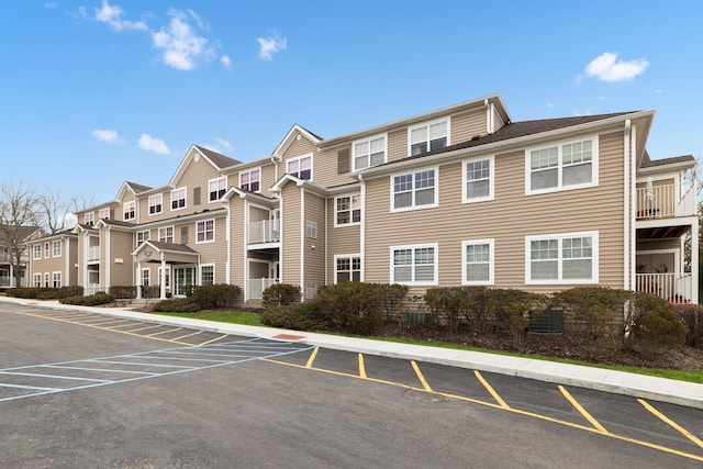 view of building exterior featuring a residential view and uncovered parking