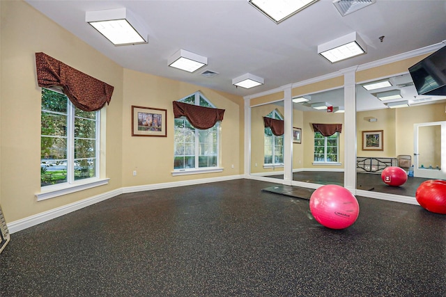 workout area featuring visible vents, a healthy amount of sunlight, and baseboards