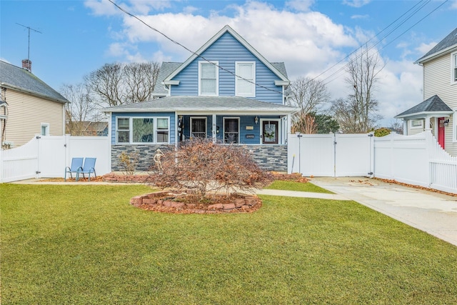 view of front of home with a front yard, a gate, fence, and stone siding