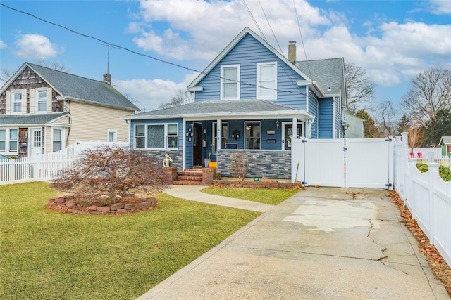 view of front of home with a front yard, a gate, covered porch, a chimney, and fence private yard