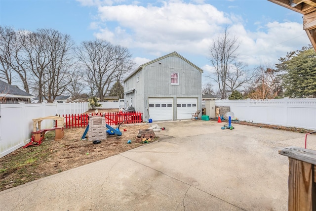 view of property exterior with an outbuilding, fence private yard, a playground, and a garage