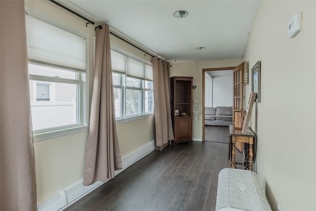 hall with baseboards, dark wood-type flooring, and baseboard heating