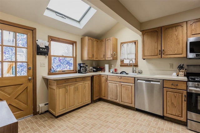 kitchen with a sink, appliances with stainless steel finishes, light countertops, and a baseboard radiator