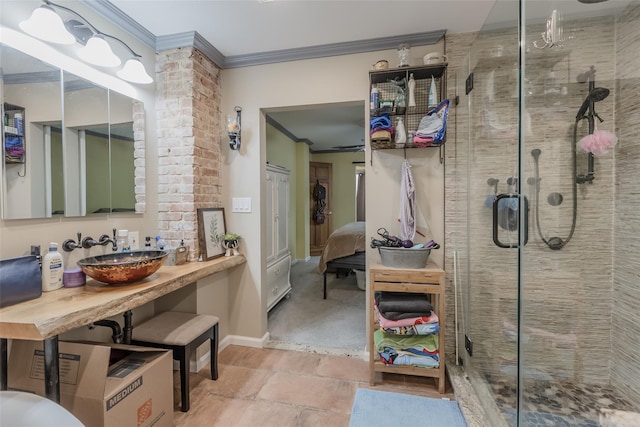 ensuite bathroom with a shower stall, connected bathroom, baseboards, ornamental molding, and a sink