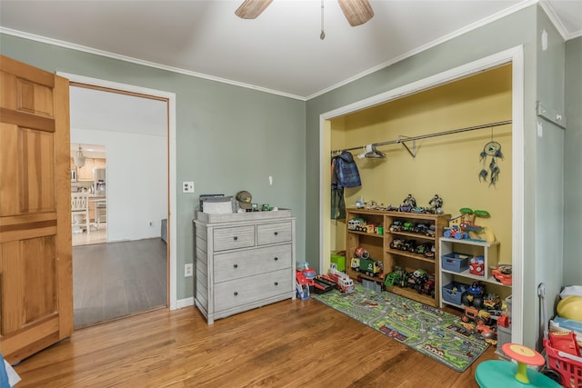 playroom with ceiling fan, wood finished floors, and crown molding