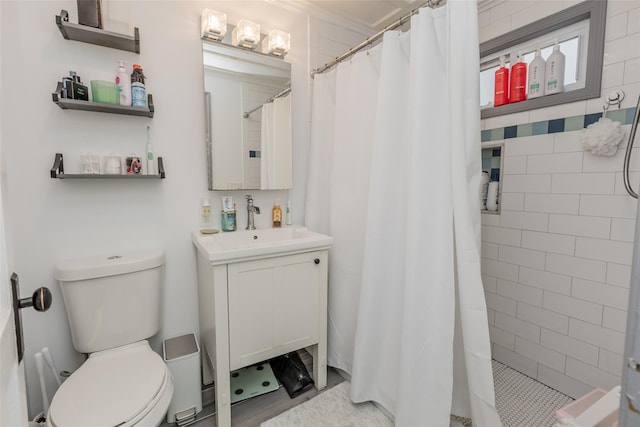 full bath with toilet, vanity, and a tile shower