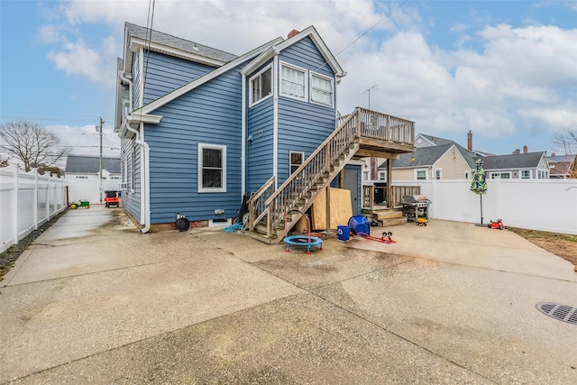 back of property featuring a deck, stairway, a patio area, and a fenced backyard