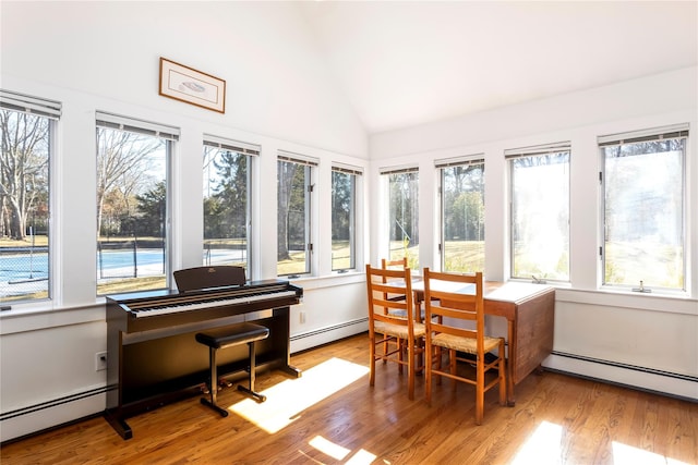 sunroom featuring lofted ceiling and a baseboard radiator