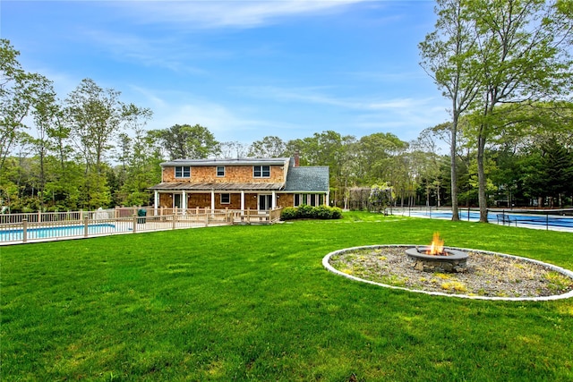 3 Arbutus Rd, Quogue, NY 11959 - rear view of property with a fire pit, a chimney, and view of wooded area