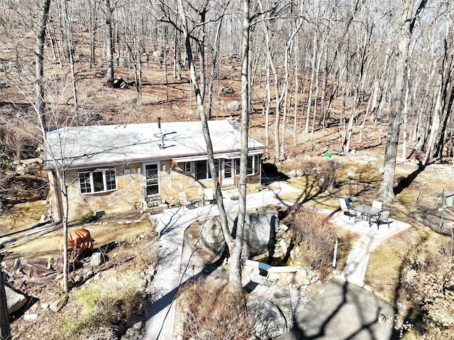 view of front of home featuring stone siding and a patio