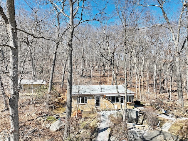 view of front of property with a wooded view