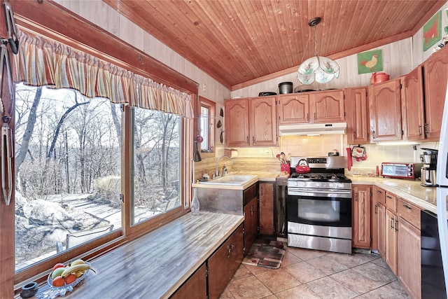 kitchen with under cabinet range hood, a sink, stainless steel range with gas cooktop, light countertops, and vaulted ceiling