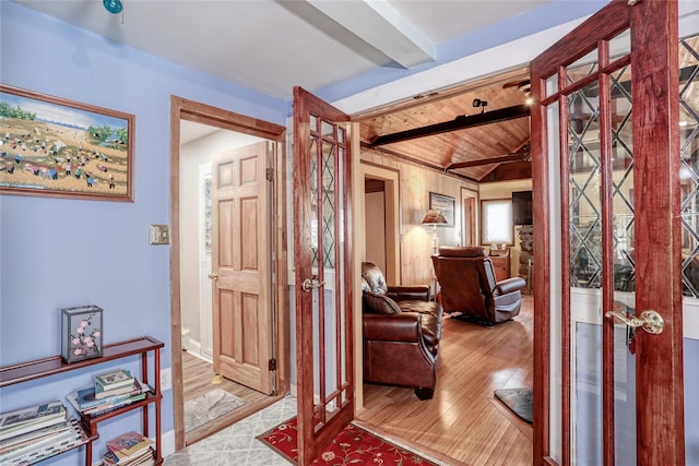 interior space featuring lofted ceiling with beams, wood finished floors, and wooden ceiling