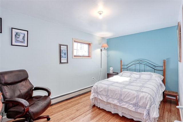 bedroom featuring a baseboard heating unit and wood finished floors