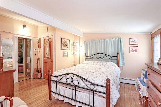 bedroom with a baseboard heating unit, lofted ceiling, light wood finished floors, and ornamental molding