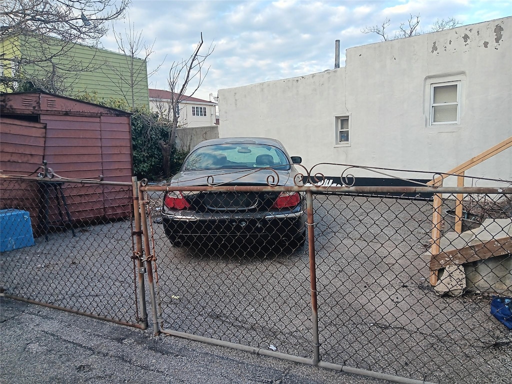 view of vehicle parking featuring a gate and fence