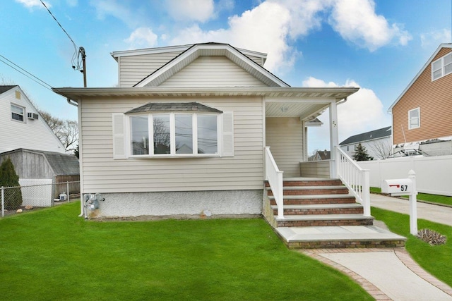 rear view of property with a lawn, a porch, and fence