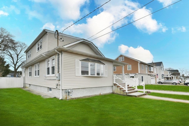 view of side of home featuring a yard, fence, and a residential view