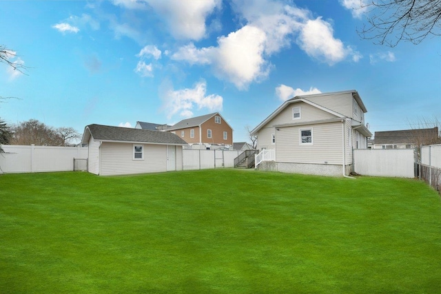 rear view of property with a lawn, an outdoor structure, and a fenced backyard