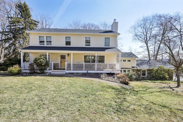 view of front of property featuring covered porch, a chimney, and a front yard