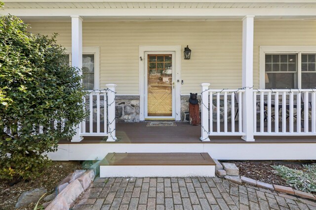 property entrance featuring stone siding and a porch