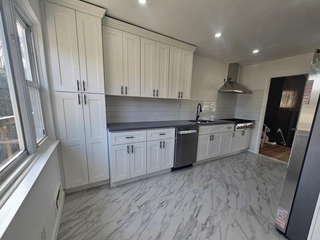 kitchen with recessed lighting, stainless steel appliances, dark countertops, wall chimney exhaust hood, and marble finish floor